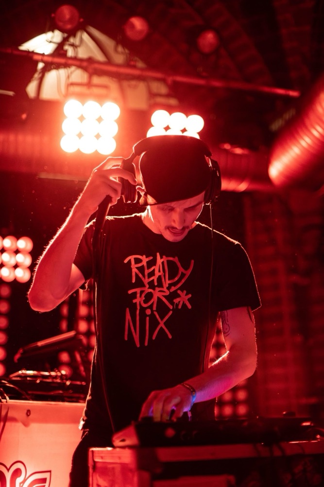 Event: DJ im roten Bühnenlicht eines Clubs