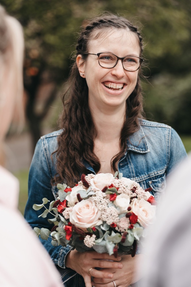 Hochzeit: lachende Braut mit Brautstrauß